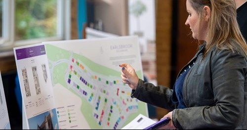 Woman stood pointing at the Laurus development map.